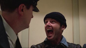 Movie still from “One Flew Over the Cuckoo's Nest” (1975), directed by Milos Forman – A man in a hat and a leather jacket is laughing; Close Up shot, Low angle