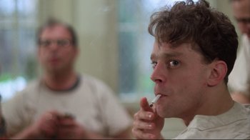 Movie still from “One Flew Over the Cuckoo's Nest” (1975), directed by Milos Forman – A man smoking a cigarette while another man looks on; Close Up shot, Low angle