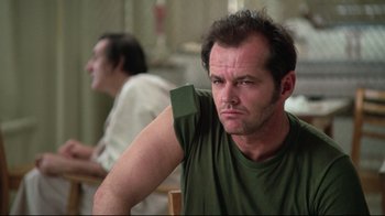 Movie still from “One Flew Over the Cuckoo's Nest” (1975), directed by Milos Forman – A person sitting in a chair; Close Up shot, Low angle