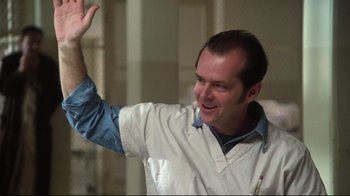 Movie still from “One Flew Over the Cuckoo's Nest” (1975), directed by Milos Forman – A man in a white shirt is waving; Medium shot, Low angle