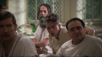 Movie still from “One Flew Over the Cuckoo's Nest” (1975), directed by Milos Forman – A group of men sitting next to each other in a room; Medium shot, Low angle