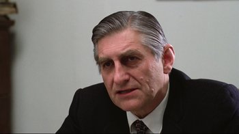 Movie still from “One Flew Over the Cuckoo's Nest” (1975), directed by Milos Forman – An older man wearing a suit and tie; Close Up shot, Over the shoulder angle