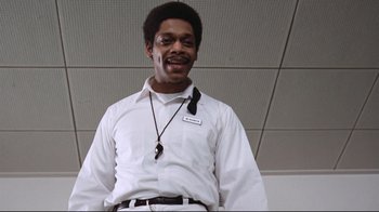 Movie still from “One Flew Over the Cuckoo's Nest” (1975), directed by Milos Forman – A man in a white dress shirt and tie smiling; Medium shot, Low angle