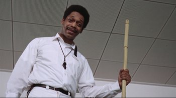 Movie still from “One Flew Over the Cuckoo's Nest” (1975), directed by Milos Forman – A man holding a stick in a room; Medium shot, Low angle