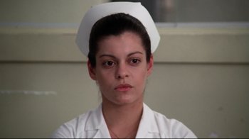Movie still from “One Flew Over the Cuckoo's Nest” (1975), directed by Milos Forman – A woman in a nurse's uniform is looking directly at the camera; Close Up shot, Low angle