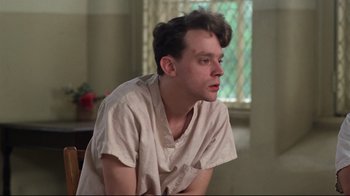 Movie still from “One Flew Over the Cuckoo's Nest” (1975), directed by Milos Forman – A man sitting in front of a window in a room; Close Up shot, Low angle