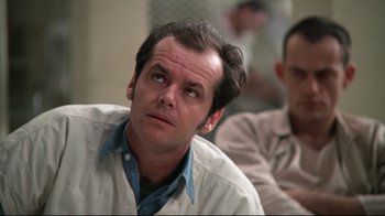 Movie still from “One Flew Over the Cuckoo's Nest” (1975), directed by Milos Forman – Jack nicholson sitting in front of another man; Close Up shot, Low angle