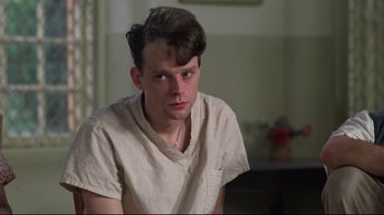 Movie still from “One Flew Over the Cuckoo's Nest” (1975), directed by Milos Forman – A young man sitting in a living room with his eyes closed; Close Up shot, High angle
