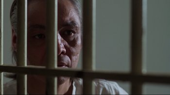 Movie still from “One Flew Over the Cuckoo's Nest” (1975), directed by Milos Forman – An older man looking through bars of a jail cell; Close Up shot, Low angle