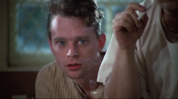 Movie still from “One Flew Over the Cuckoo's Nest” (1975), directed by Milos Forman – A young man holding a white cloth over his face; Close Up shot, Low angle