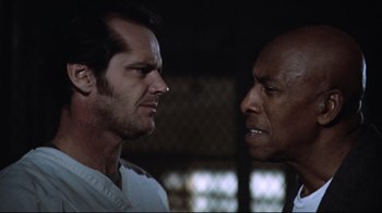 Movie still from “One Flew Over the Cuckoo's Nest” (1975), directed by Milos Forman – Two men face each other in a dark room; Close Up shot, Low angle