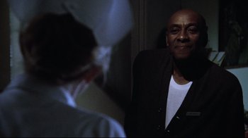 Movie still from “One Flew Over the Cuckoo's Nest” (1975), directed by Milos Forman – A man standing in front of a mirror in a dark room; Close Up shot, Over the shoulder angle