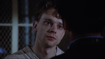 Movie still from “One Flew Over the Cuckoo's Nest” (1975), directed by Milos Forman – A man with blue eyes looking at the camera; Close Up shot, Over the shoulder angle