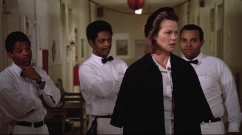 Movie still from “One Flew Over the Cuckoo's Nest” (1975), directed by Milos Forman – A group of people standing in a room; Medium shot, Low angle