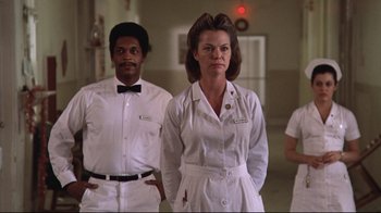 Movie still from “One Flew Over the Cuckoo's Nest” (1975), directed by Milos Forman – A couple of people standing next to each other in a room; Medium shot, Low angle