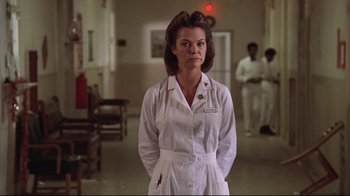 Movie still from “One Flew Over the Cuckoo's Nest” (1975), directed by Milos Forman – A woman in a white lab coat standing in a room; Medium shot, Low angle