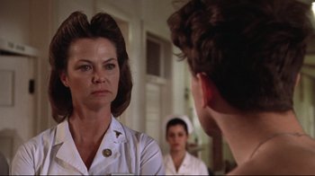 Movie still from “One Flew Over the Cuckoo's Nest” (1975), directed by Milos Forman – A woman looking in the mirror in front of a man; Close Up shot, Over the shoulder angle