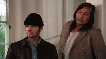 Movie still from “One Flew Over the Cuckoo's Nest” (1975), directed by Milos Forman – Two men standing next to each other in front of a wall; Medium shot, Low angle