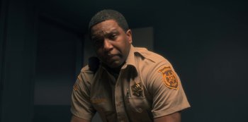 Movie still from “The Haunting of Hill House” (2018), directed by Mike Flanagan – A man in a police uniform is looking at the camera; Close Up shot, Over the shoulder angle