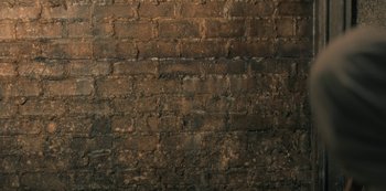 Movie still from “The Haunting of Hill House” (2018), directed by Mike Flanagan – A brick wall with a lot of dirt on it; Extreme Close Up shot, Overhead angle
