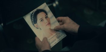 Movie still from “The Haunting of Hill House” (2018), directed by Mike Flanagan – A person holding up a picture of a woman; Extreme Close Up shot, Over the shoulder angle