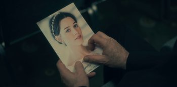 Movie still from “The Haunting of Hill House” (2018), directed by Mike Flanagan – A person holding a picture of a woman; Extreme Close Up shot, Over the shoulder angle