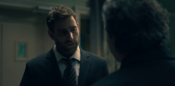 Movie still from “The Haunting of Hill House” (2018), directed by Mike Flanagan – A man wearing a suit and tie talking to another man; Close Up shot, Over the shoulder angle