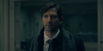 Movie still from “The Haunting of Hill House” (2018), directed by Mike Flanagan – A person wearing a suit and tie; Close Up shot, Low angle