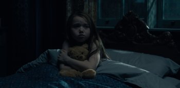 Movie still from “The Haunting of Hill House” (2018), directed by Mike Flanagan – A little girl sitting on a bed with a teddy bear; Medium shot, High angle