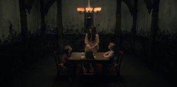 Movie still from “The Haunting of Hill House” (2018), directed by Mike Flanagan – A group of people sitting around a table; Wide shot, Over the shoulder angle