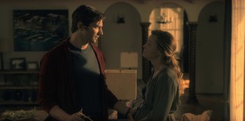 Movie still from “The Haunting of Hill House” (2018), directed by Mike Flanagan – A man and a woman shaking hands in a living room; Medium shot, Over the shoulder angle