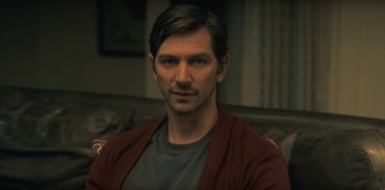 Movie still from “The Haunting of Hill House” (2018), directed by Mike Flanagan – A person sitting on a couch; Close Up shot, Over the shoulder angle
