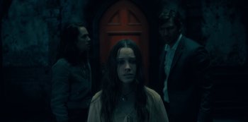 Movie still from “The Haunting of Hill House” (2018), directed by Mike Flanagan – A group of people standing in front of a red door; Medium shot, Over the shoulder angle
