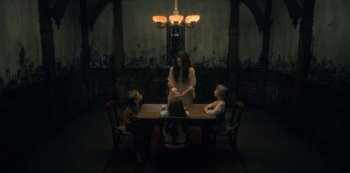 Movie still from “The Haunting of Hill House” (2018), directed by Mike Flanagan – A group of people sitting around a table; Wide shot, High angle