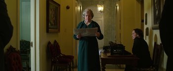 Movie still from “The Highwaymen” (2019), directed by John Lee Hancock – An older woman standing in front of an old fashioned typewriter; Medium shot, Low angle