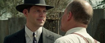 Movie still from “The Highwaymen” (2019), directed by John Lee Hancock – A man wearing a suit and hat talking to another man wearing a hat; Close Up shot, Over the shoulder angle