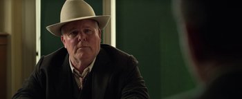 Movie still from “The Highwaymen” (2019), directed by John Lee Hancock – A person wearing a suit and a hat; Close Up shot, Over the shoulder angle