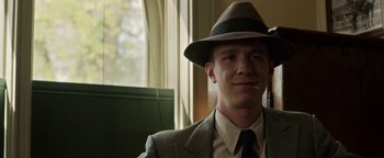 Movie still from “The Highwaymen” (2019), directed by John Lee Hancock – A man in a suit and a hat smoking a cigarette; Close Up shot, Low angle