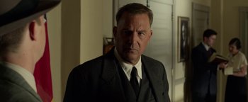 Movie still from “The Highwaymen” (2019), directed by John Lee Hancock – An older man wearing a suit and tie; Close Up shot, Low angle