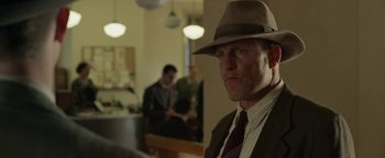 Movie still from “The Highwaymen” (2019), directed by John Lee Hancock – A man wearing a hat and a tie; Close Up shot, Over the shoulder angle