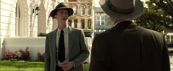Movie still from “The Highwaymen” (2019), directed by John Lee Hancock – A man wearing a suit and hat talking to another man wearing a hat; Medium shot, Over the shoulder angle