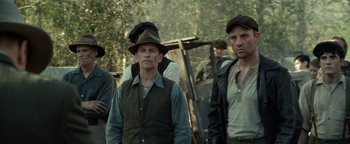 Movie still from “The Highwaymen” (2019), directed by John Lee Hancock – A group of men standing next to each other on top of a hill; Medium shot, Low angle