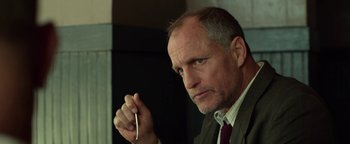 Movie still from “The Highwaymen” (2019), directed by John Lee Hancock – A man in a suit and tie holding a pen; Close Up shot, Low angle