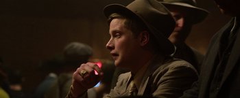 Movie still from “The Highwaymen” (2019), directed by John Lee Hancock – A man wearing a hat and holding a cell phone in his hand; Close Up shot, Over the shoulder angle