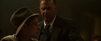 Movie still from “The Highwaymen” (2019), directed by John Lee Hancock – A man and a boy in a suit and tie; Close Up shot, Over the shoulder angle