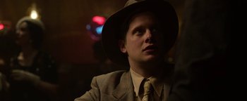 Movie still from “The Highwaymen” (2019), directed by John Lee Hancock – A man wearing a hat and a suit and tie; Close Up shot, Over the shoulder angle