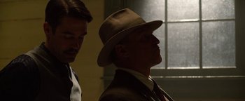 Movie still from “The Highwaymen” (2019), directed by John Lee Hancock – A man wearing a hat and a suit and tie; Medium shot, Low angle