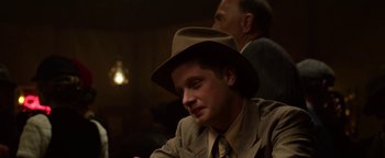Movie still from “The Highwaymen” (2019), directed by John Lee Hancock – A man wearing a hat sitting in a room; Close Up shot, Over the shoulder angle