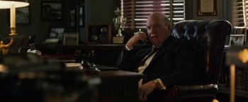 Movie still from “The Highwaymen” (2019), directed by John Lee Hancock – A man sitting at a table talking on a phone; Medium shot, Low angle