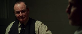 Movie still from “The Highwaymen” (2019), directed by John Lee Hancock – An older man wearing a vest and a tie; Close Up shot, Over the shoulder angle